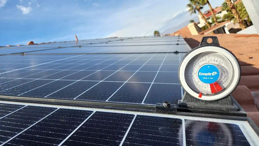 Close-up of solar panels on a roof with a meter indicating energy production.