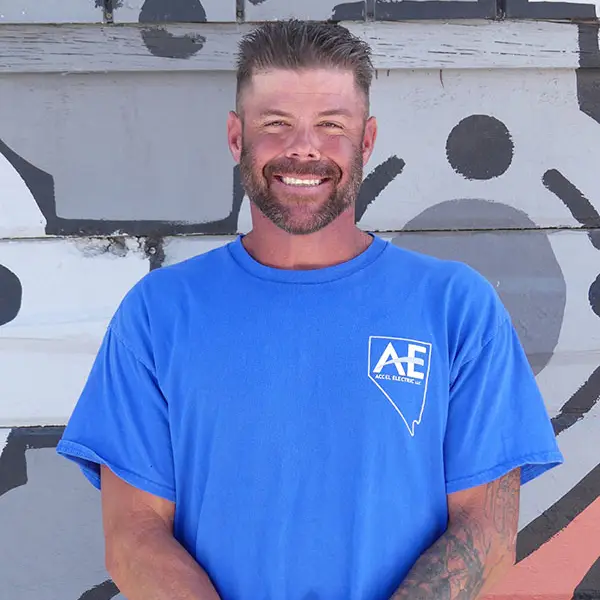 Man smiling while wearing a blue t-shirt with the Accel Electric logo on it.