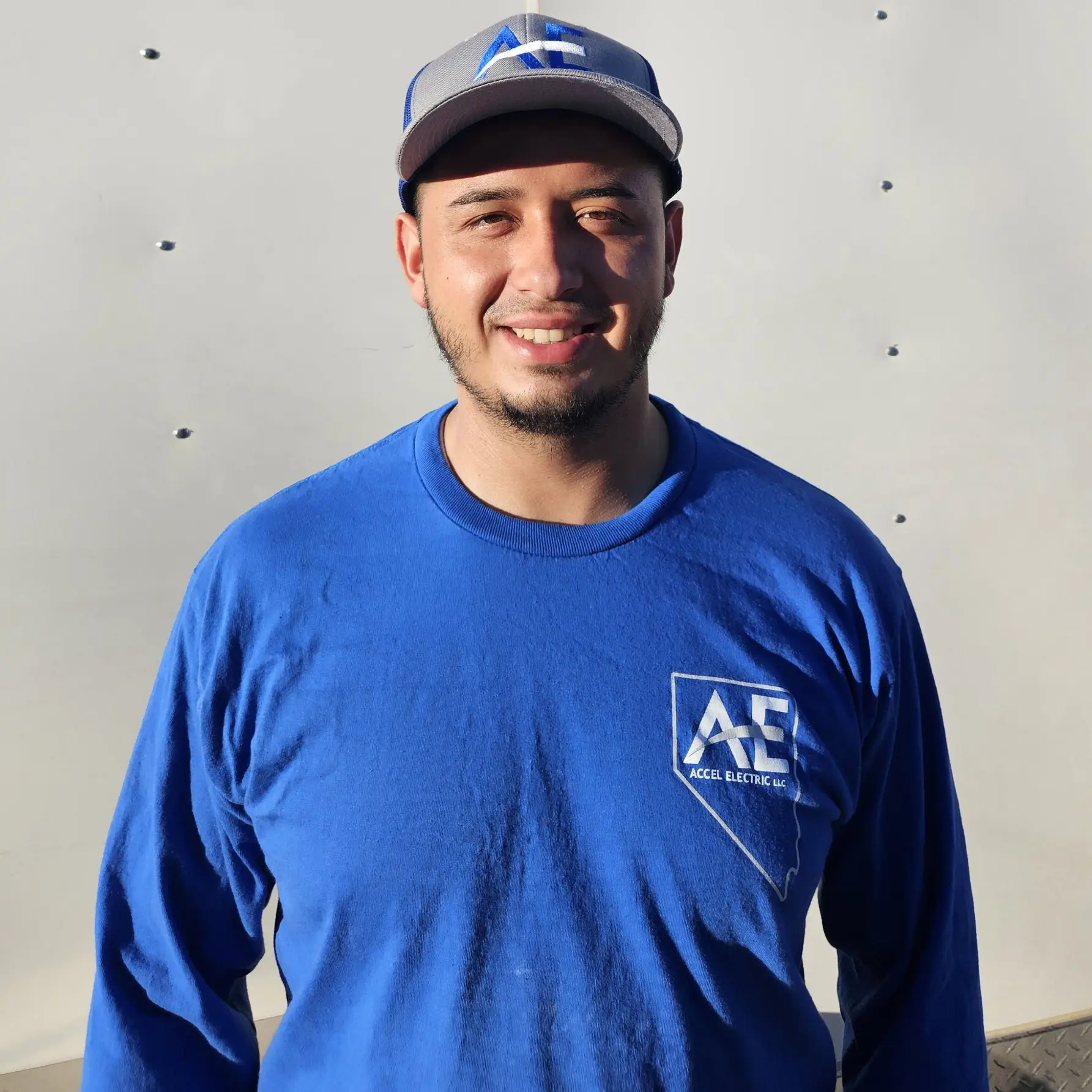 Employee of Accel Electric wearing a blue shirt and cap with the company logo.