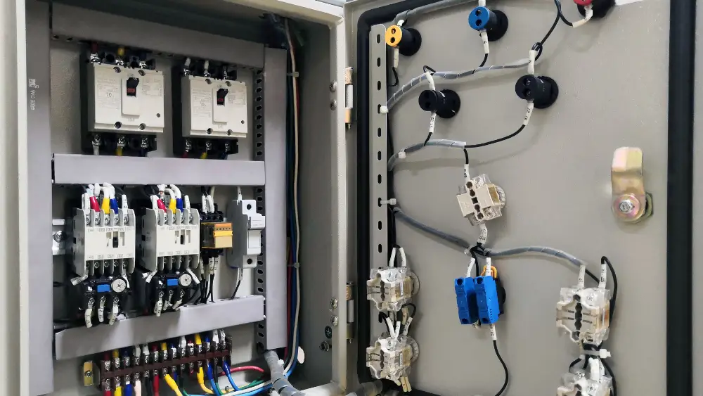 Electrical panel showing circuit breakers, wiring connections, and terminal blocks in a structured layout.